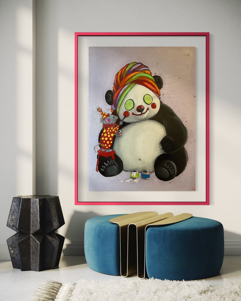Framed illustration of a smiling panda clown wearing a colorful striped hat, holding a doll, displayed above a blue ottoman and dark vase